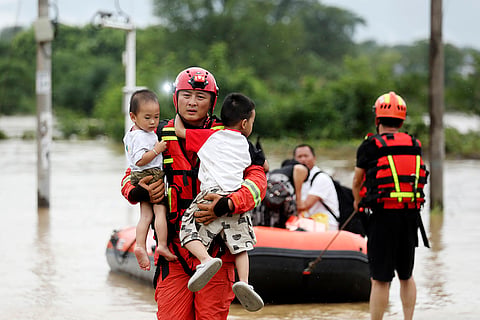 Rescuer evacuates children in Zixing city